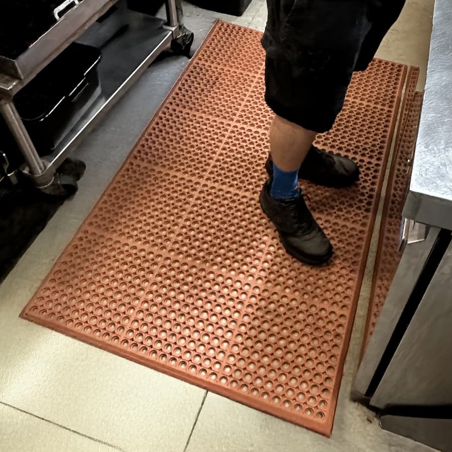 person standing on workstation mat
